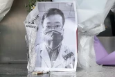 Une photo du médecin Li Wenliang, devant laquelle a été déposé un bouquet de fleurs, devant une aile de l'hôpital de Wuhan, en Chine, le 7 février 2020 