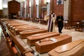 Un prêtre bénit les cercueils de personnes décédées du Covid-19, dans l'église de San Giuseppe à Seriate, dans le nord de l'Italie, le 28 mars 2020