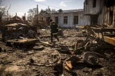 Un pompier ukrainien au milieu des décombres à Trostianets, nord-est de l'Ukraine, le 29 mars 2022
