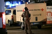 Un policier devant un véhicule de la Croix-Rouge le 24 août 2024 à Solingen, dans l'ouest de l'Allemagne, après une attaque meurtrière au couteau