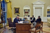 Le président américain Donald Trump (g)dans le bureau ovale en compagnie de ses conseillers Steve Bannon (d) et Michael Flynn (c) le 28 janvier 2017