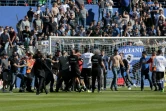 Des supporters bastiais envahissent la pelouse du stade Armand-Cesari pour tenter d'agresser le gardien de Lyon Anthony Lopes (rouge) à l'échauffement, le 16 avril 2017