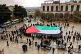 Un immense drapeau palestinien déplié sur la place de la Mangeoire, le 24 décembre 2023 dans l'eglise de la Naticité à Bethléem en Cisjordanie occupée

