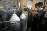 Des employés remplissent des bouteilles d'oxygène dans une usine à Taji, au nord de Bagdad, le 5 juillet 2020 en Irak