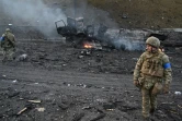 Des militaires ukrainiens recherchent des obus non explosés après des combats contre des Russes à Kiev, le 26 février 2022

