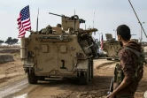 Un combattant des Forces démocratiques syriennes, dominées par les Kurdes, regarde un convoi américain passer près de la ville de Qamichli, dans le nord-est de la Syrie, le 2 novembre 2019