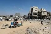 Des Palestiniens récupèrent des affaires dans un secteur oriental de Deir al Balah, dévasté par les hostilités, dont l'armée israélienne s'est retirée, le 29 aout 2024