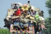 Des habitants et leurs biens entassés sur un tracteur quittent les zones inondées, le 30 août 2022 à Shikarpur, dans la province du Sind, au Pakistan