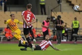 Le milieu de Barcelone, Antoine Griezmann (g), défie les défenseurs de l'Athletic Bilbao, Inigo Martinez (d) et Yeray Alvarez, lors de la finale de la Coupe du Roi, à Séville, le 17 avril 2021