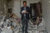 Un homme tient un chaton trouvé dans les ruines de son apartement après un bombardement, le 10 octobre 2020 à Tartar, en Azerbaïdjan