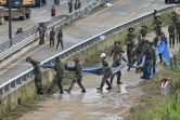 Des militaires portent un tuyau pour pomper l'eau qui s'est engouffrée dans un tunnel dans lequel 15 voitures ont été prises au piège des fortes pluies qui se sont abattues sur Cheongju, en Corée du Sud, le 16 juillet 2023