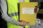 Un "gilet jaune" montre le cahier de doléances qu'il présente sur un rond-point à Cagnes-sur-mer, le 20 décembre 2018