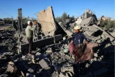 Des hommes récupèrent des objets au milieu des ruines d'un bâtiment après un bombardement israélien, le 13 janvier 2024 à Rafah dans la bande de Gaza