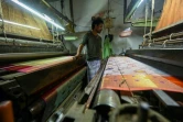 Tissage d'un sari sur un métier mécanique dans un atelier de Varanasi, le 20 novembre 2021 en Inde