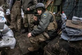 Un militaire ukrainien fume une  cigarette dans une tranchée près de Kharkiv le 31 mars 2022