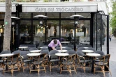 Un employé du "café du Trocadero" à Paris, nettoie les tables de la terrasse, le 11 mais 2021, une semaine avant la réouverture prévue des terrasses