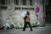 Une femme va déposer des fleurs devant la collégiale de  Saint-Donat-sur-l'Herbasse, avant les obsèques de Thomas, un adolescent de 16 ans tué en marge d'un bal de village dans la Drôme, le 24 novembre 2023