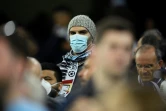 Un amateur de football, le visage couvert d'un masque de protection contre le coronavirus, assiste au match de l'Olympique lyonnais contre la Juventus Turin en huitième de finale aller de Ligue des champions, à Lyon (France) le 26 février 2020