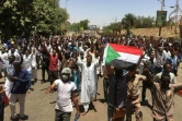Des manifestants soudanais brandissent le drapeau du Soudan en marchant vers le QG de l'armée à Khartoum, le 8 avril 2019