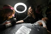 Une femme profite du festival "Art Weapon" à Kiev pour se faire tatouer, le 14 mai 2022
