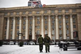 Deux combattants séparatistes pro-russes marchent près d'un bâtiment officiel à Donestsk, dans l'est de l'Ukraine, le 18 janvier 2022.