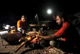 Des randonneurs et leur guide dînent à la belle étoile près du cratère volcanique d'Al Wahbah, à quelque 360 km de Jeddah, en Arabie saoudite, le 17 novembre 2017