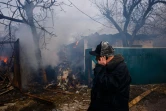 Un homme parle au téléphone devant sa maison qui brûle dans la ville de Tcherniguiv sévèrement bombardée en Ukraine le 4 mars 2022