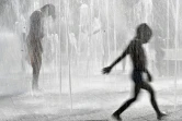 Des enfants se rafraichissent sous une fontaine à Colmar le 7 août 2020
