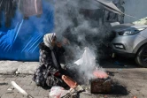 Une déplacée palestinienne utilise un réchaud de fortune pour cuisiner  dans une rue de Rafah, dans le sud de la bande de Gaza, à la frontière avec l'Egypte, le 11 février 2024