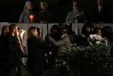 Les infirmières ukrainienne Irina (3e g) et russe Albina (4e g) portent le crucifix et le remettent à un migrant entre la 13e et dernière station du Chemin de Croix au Colisée de Rome, le 15 avril 2022