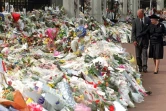 La reine Elizabeth II et son mari le duc d'Edimbourg, regardent le 5 septembre 1997 les milliers de bouquets déposés à la mémoire de Diana devant Kensington Palace où elle résidait à Londres 