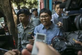 Le journaliste birman Wa Lone (c) escorté par des policiers après son procès à Rangoun, le 4 avril 2018