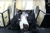 Une capture d'écran de la NASA TV montre l'astronaute Victor Glover (C) sortant de la capsule après son retour sur terre le 2 mai 2021