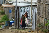 Une habitante étend du linge dans le bidonville la "Cité de Dieu", dans le quartier du Mont Sinai à Guayaquil, le 26 juillet 2022 en Equateur