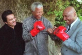 Le boxeur panaméen Roberto Duran (g), le président sud-africain Nelson Mandela (c) et l'ex-boxeur américain Marvin Hagler au Cap (Afrique du Sud), le 12 novembre 1997