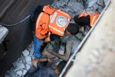 Des secouristes et des civils retirent le corps d'un homme sous les gravats après une frappe israélienne sur le camp de réfugiés de Nousseirat, dans le centre de la bande de Gaza, le 6 juillet 2024