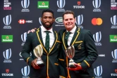 Le sélectionneur des Springboks Rassie Erasmus (d) et leur capitaine Siya Kolisi posent avec leur trophée lors de la cérémonie des Awards 2019 de rugby, le 3 novembre 2019 à Tokyo 