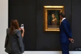 Un couple regarde le tableau "La Belle Ferronière" de Léonard De Vinci au Louvre Abou Dhabi lors d'une visite organisée pour les médias le 6 novembre 2017