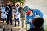Un médecin effectue un prélèvement sur une femme pour un test au Covid-19, le 13 mai 2020 à Johannesburg, en Afrique du Sud