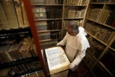 Le père Najeeb Michaeel regarde un ancien manuscrit au Centre de numérisation des manuscrits orientaux (CNMO) à Erbil, dans le nord de l'Irak, le 1er mars 2018