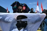 Une femme portant une coiffe alsacienne porte un drapeau corse le 29 mai 2021 à Colmar lors d'une manifestation pour la défense des langues régionales