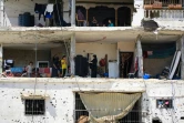 Des familles palestiniennes retournent dans leurs maisons gravement endommagées dans un immeuble touché lors d'un précédent bombardement israélien, dans la ville de Khan Younés, dans le sud de la bande de Gaza, le 30 juin 2024