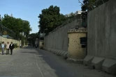 Des Afghans marchent dans une rue de la Zone verte protégée par des murs de béton de 6 mètres de haut et des barbelés à leur sommet, le 19 juin 2019 à Kaboul
