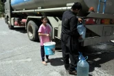 Des Kurdes irakiens s'approvisionnent en eau lors d'une distribution par camion, à Erbil, capitale du Kurdistan autonome dans le nord de l'Irak, qui souffre d'une pénurie d'eau courante, le 25 juillet 2024