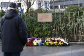 Un homme devant la plaque à la mémoire d'Ahmed Merabet, le 5 janvier 2017 devant Charlie Hebdo à Paris