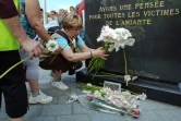 Des veuves de salariés victimes de l'amiante déposent le 20 juin 2009 à Dunkerque, des fleurs au pied d'une stèle dédiée à la mémoire de leurs proches décédés.