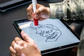 Le tatoueur japonais Ichi Hatano dessine une "hannya" (fantôme femme)  sur tablette tactile dans son studio à Tokyo, le 22 juin 2021