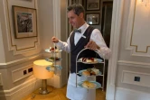 Un serveur apporte un plateau de pâtisseries accompagnant le "afternoon tea", à l'hôtel Kensington de Londres, le 11 août  2016