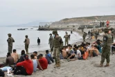 Des soldats espagnols gardent des migrants arrivés à la nage à l'enclave espagnole de Ceuta, le 18 mai 2021
