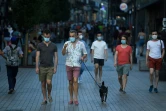 Des passants portant des masques obligatoires dans les lieux publics marchent dans le centre de Madrid le 30 juillet 2020 